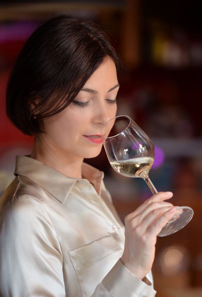 ritratto di Mina sommelier che valuta un vino